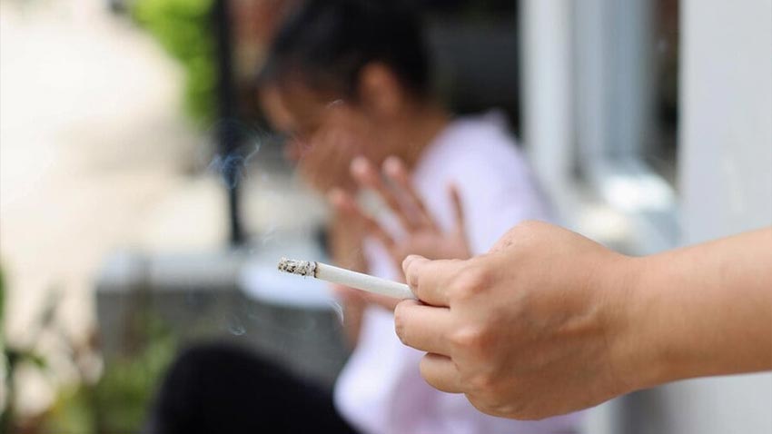 Om care fumeaza o tigara langa o femeie gravida