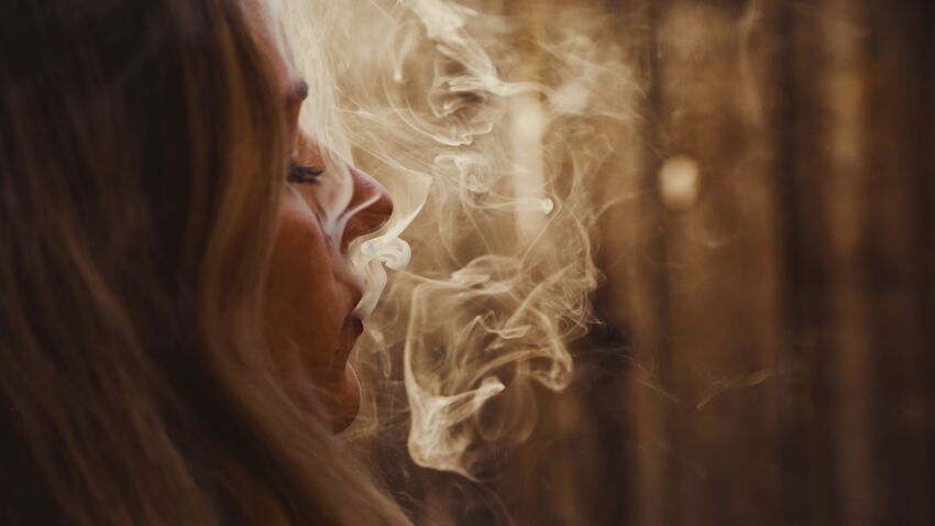 femeie cu parul blond care fumeaza