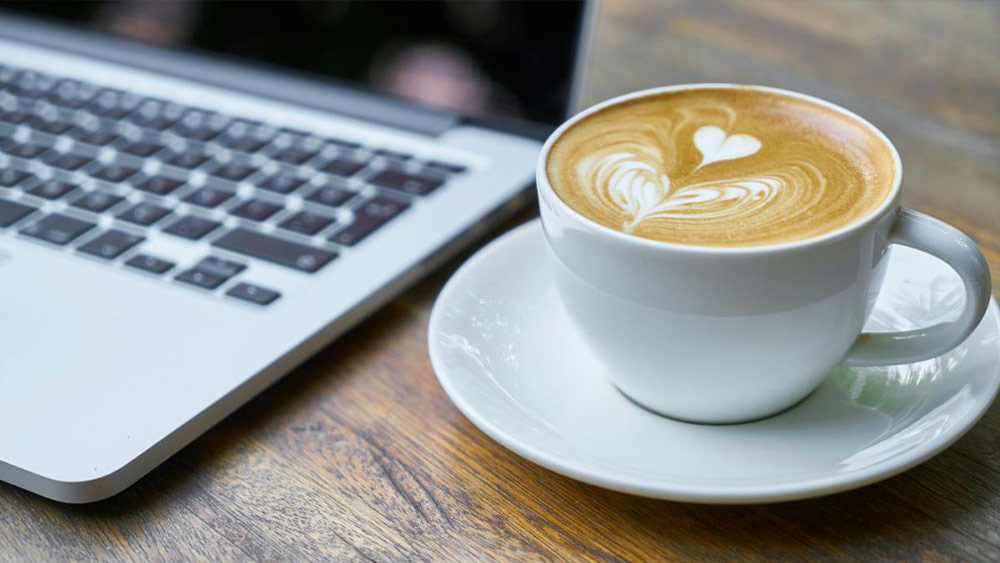 cana de cafea langa laptop