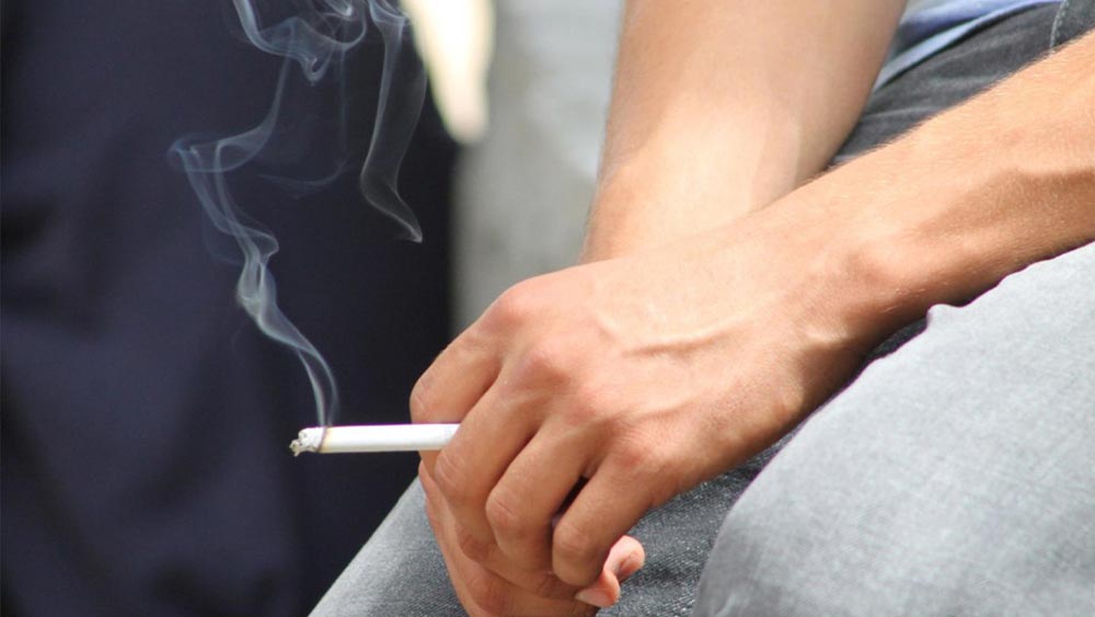 persoana care fumeaza o tigara