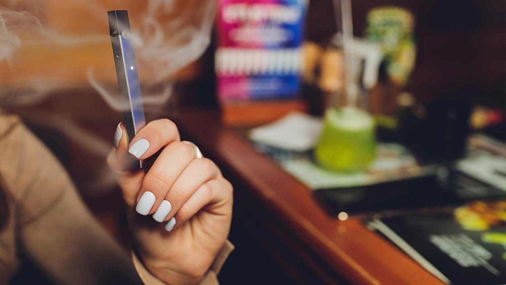 o femeie care fumeaza o tigara electronica