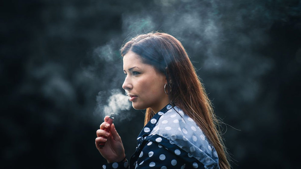 Femeie care fumeaza dintr-un vape
