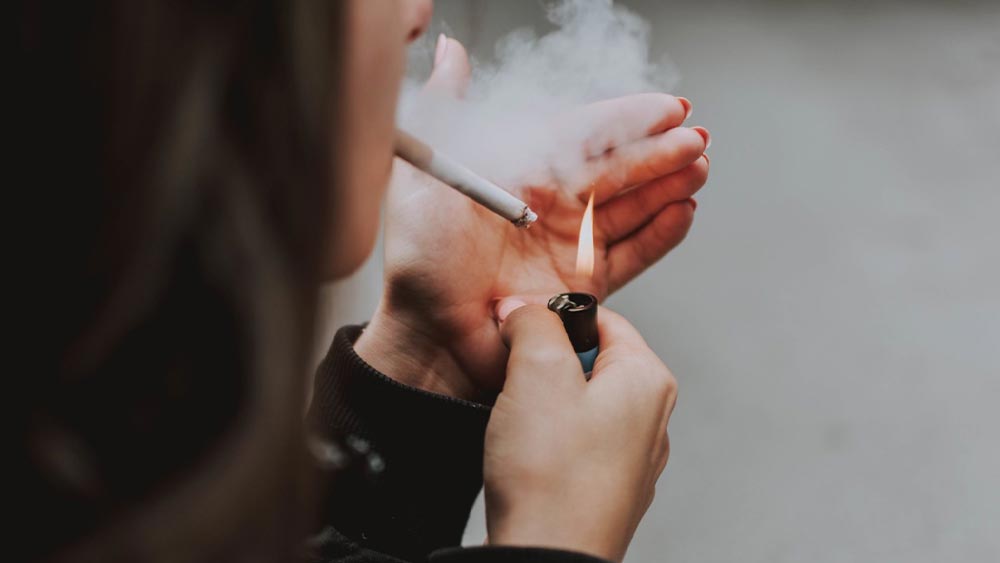 femeie care isi aprinde o tigara