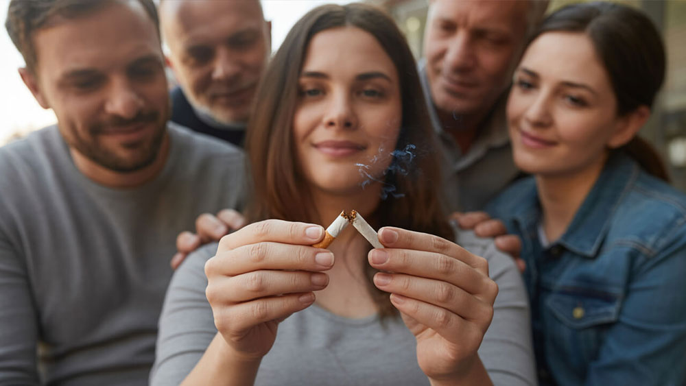 femeie insarcinata care rupe o tigara in fata familiei
