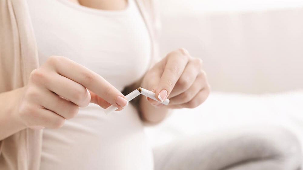 femeie insarcinata care rupe o tigara