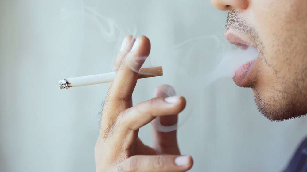 Barbat care fumeaza o tigara injectata