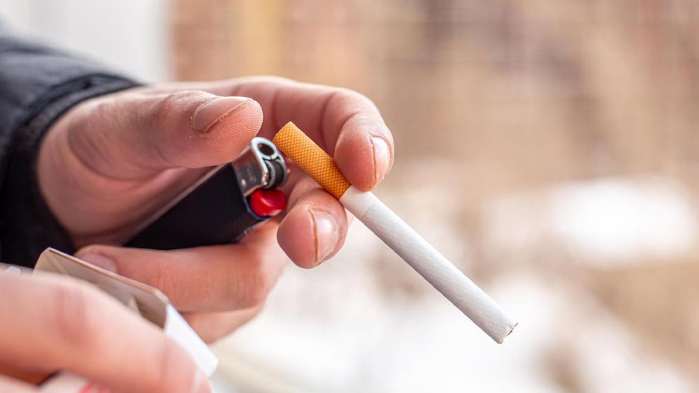 Persoana care tine o tigara in mana gata sa o aprinda