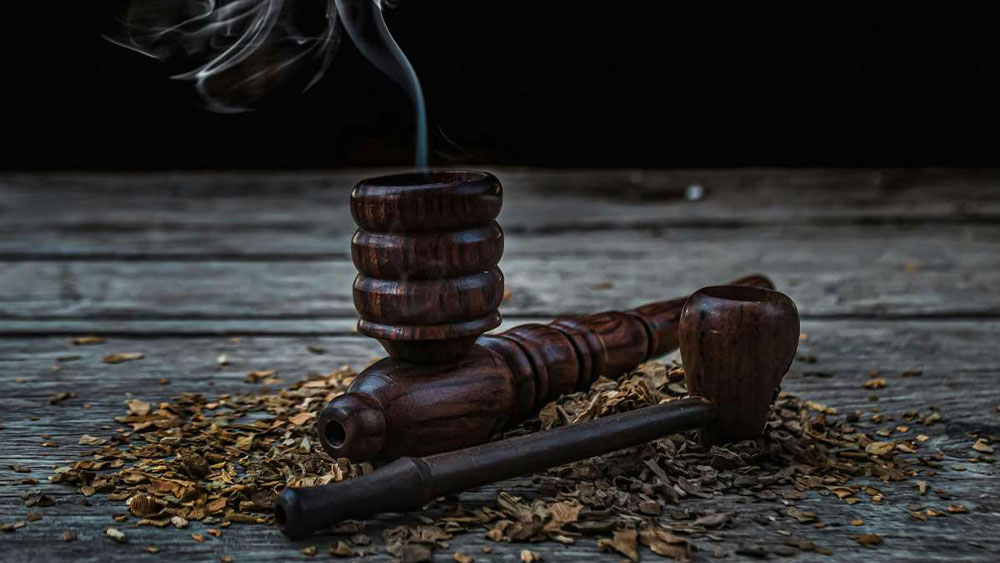 Doua pipe traditionale din lemn langa tutun de pipa
