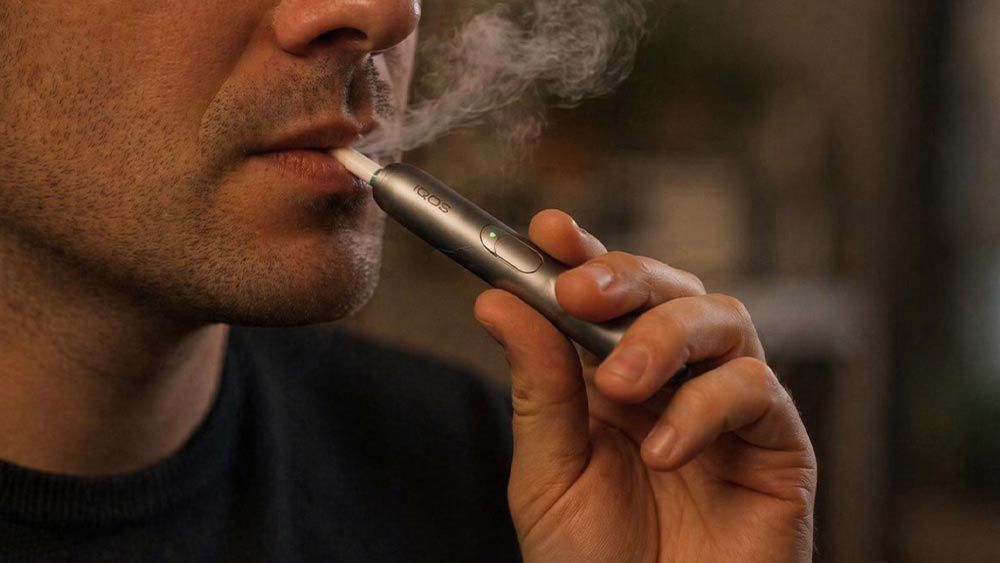 Barbat care fumeaza tutun incalzit