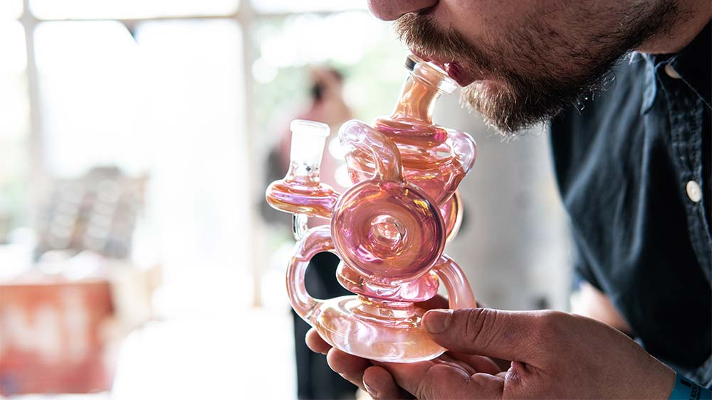Barbat care fumeaza din bong